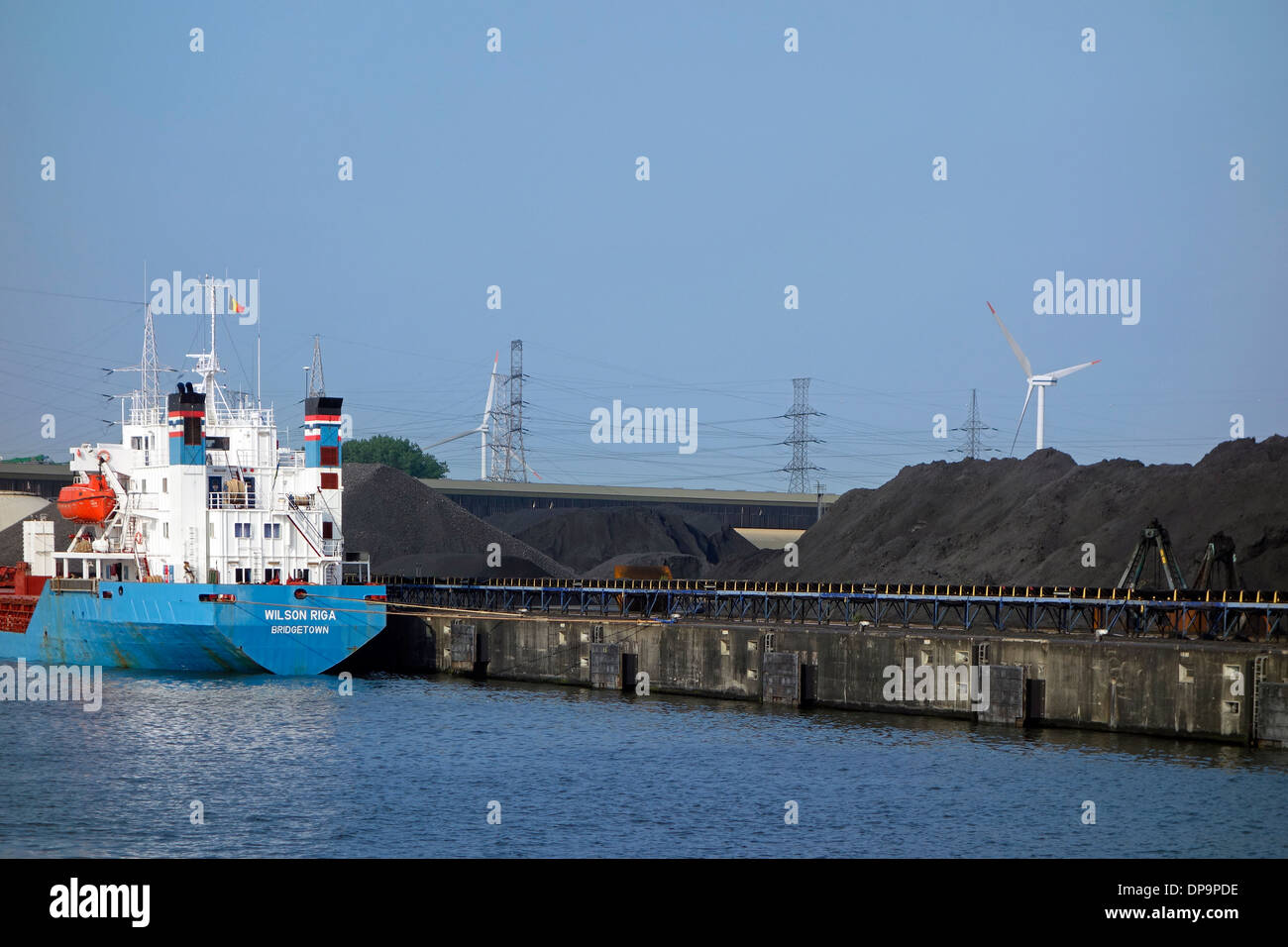 Vraquier amarré en face d'un tas de charbon en mer-invest / Ghent Coal Terminal / GCT, port de Gand, Flandre orientale, Belgique Banque D'Images