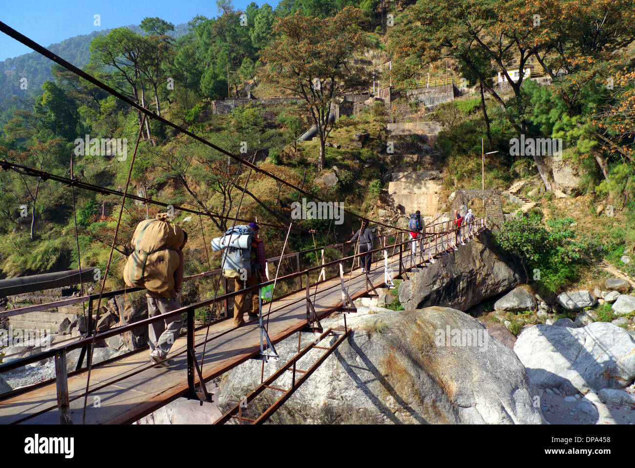 Les porteurs, les villageois et les randonneurs traversent un pont suspendu à Gehra, nr Mcleodganj, Himachal Pradesh, Inde du Nord. Banque D'Images