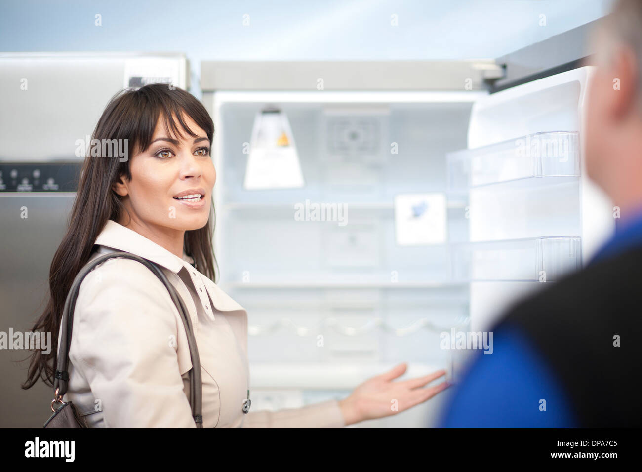 Woman looking at réfrigérateur in showroom Banque D'Images