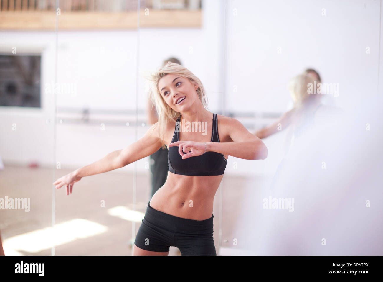 Young woman stretching en classe d'aérobie Banque D'Images