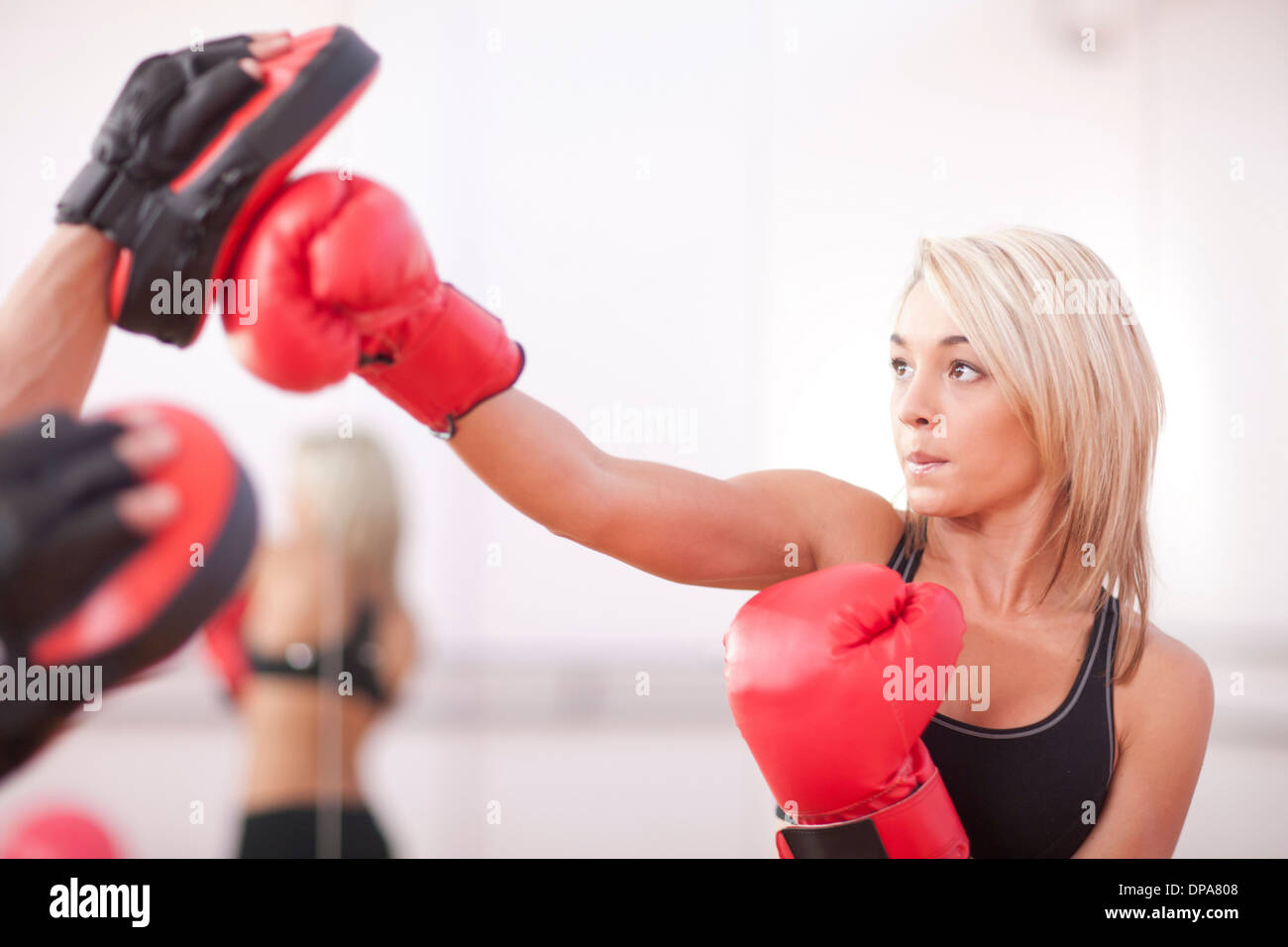 Jeune femme en formation des gants de boxe Banque D'Images
