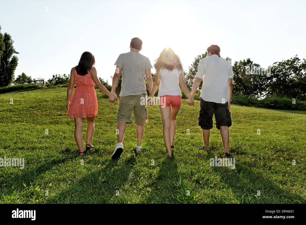 Groupe de jeunes adultes walking and holding hands Banque D'Images