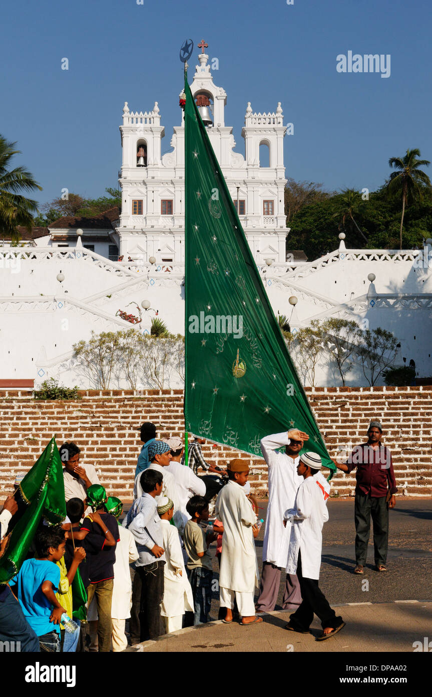 Les personnes portant un drapeau musulman en face de l'église Pajim, Goa, Inde Banque D'Images