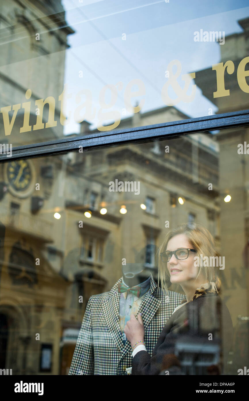 Woman putting jacket sur shop dummy Banque D'Images