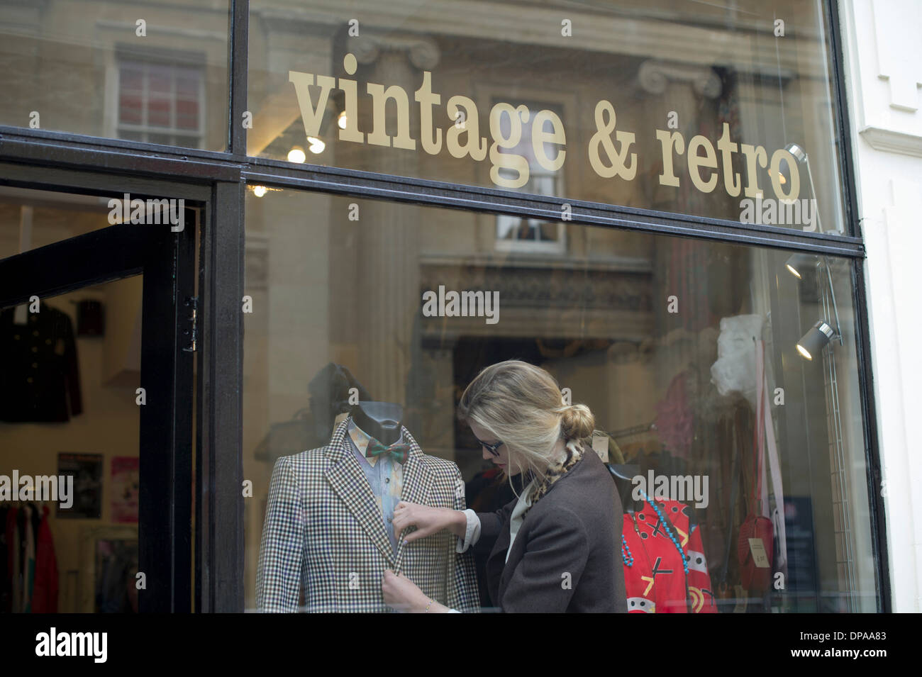 Woman putting jacket sur shop dummy Banque D'Images
