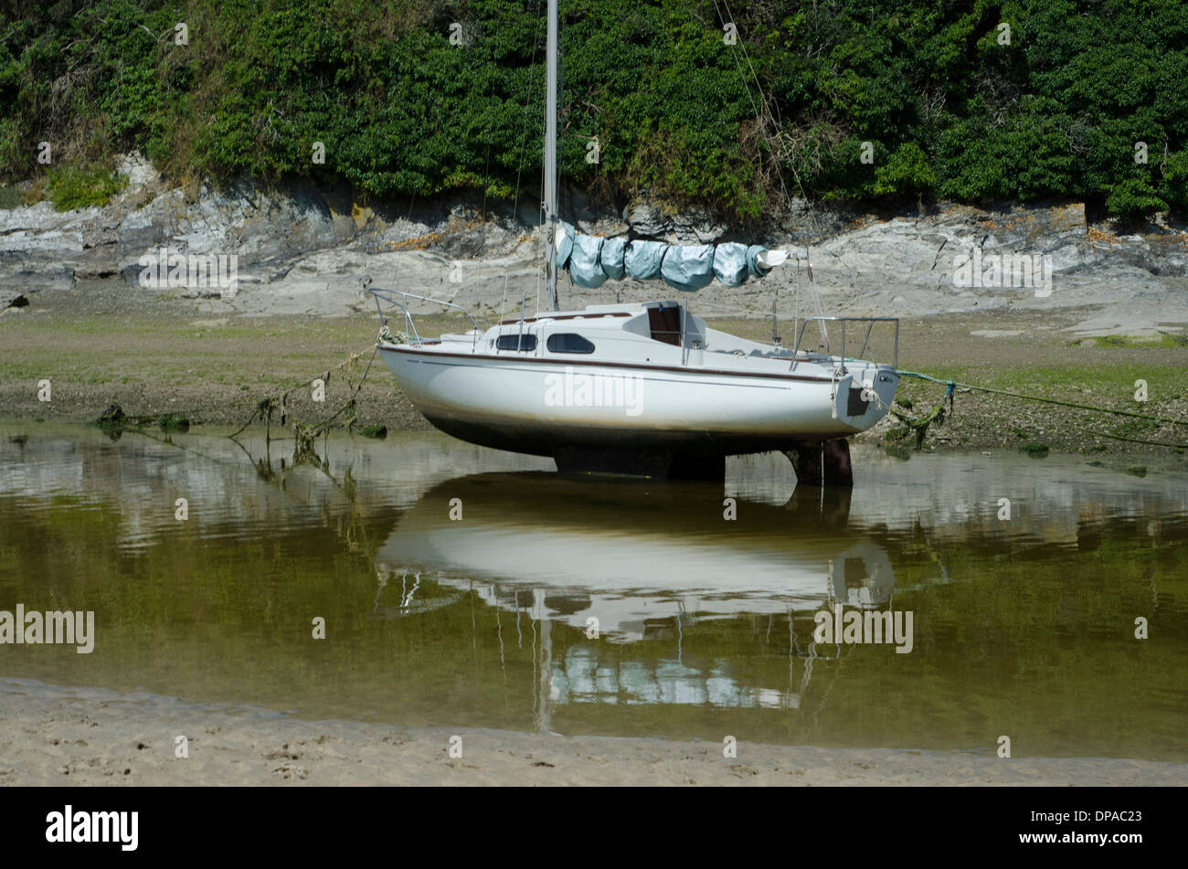 Un petit yacht assis dans le sable tandis que la marée est à Newquay Banque D'Images