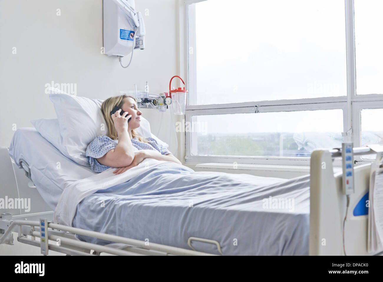 Patient allongé sur le lit d'hôpital sur appel téléphonique Banque D'Images