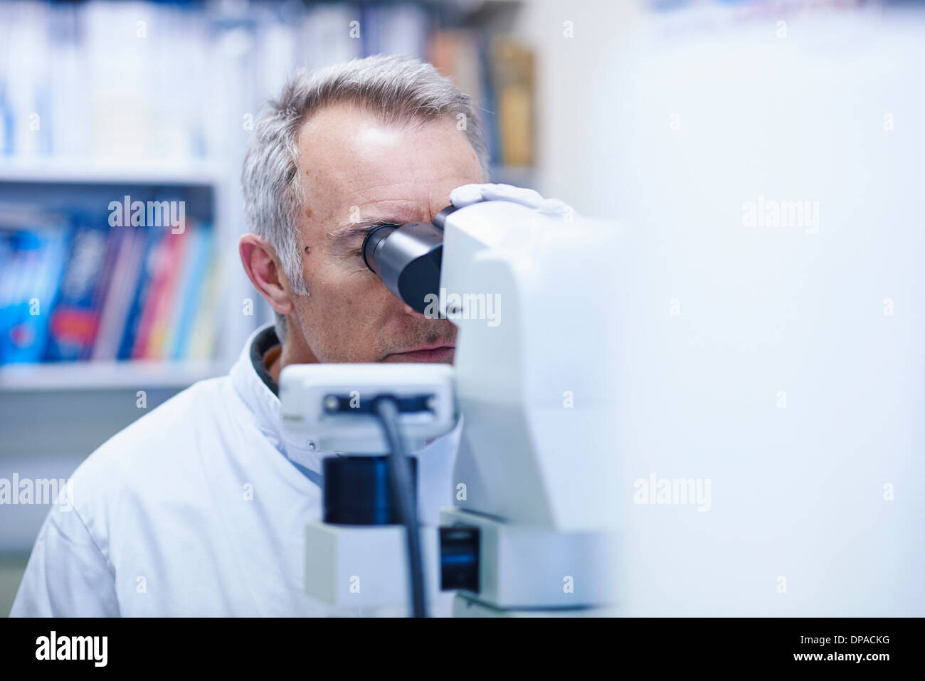 Man looking through microscope Banque D'Images