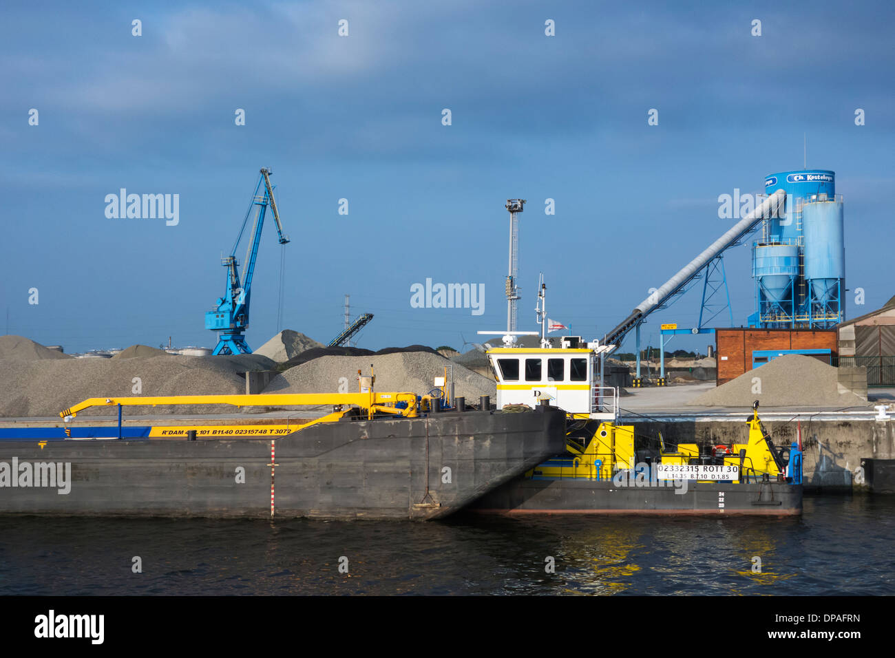 Grue de quai, des barges et des tas de sable à la Ch. Kesteleyn gravel terminal dans le port de Gand, Flandre orientale, Belgique Banque D'Images