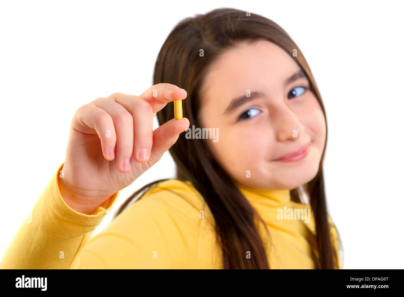 Young Girl holding capsule et à la recherche à l'appareil photo Banque D'Images