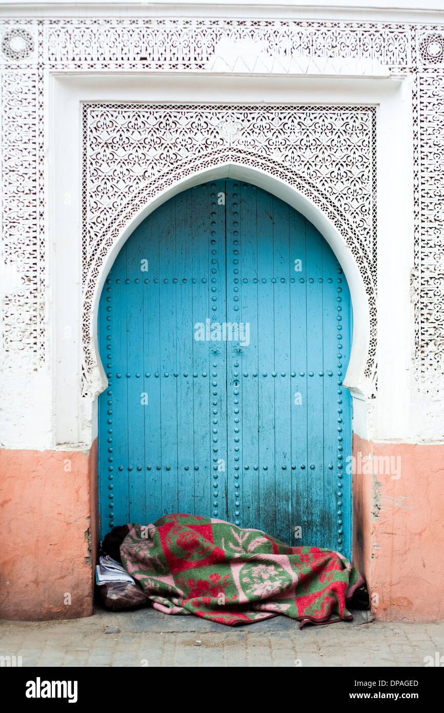 Porte marocaine avec personne sans-abri endormi, Marrakech Banque D'Images