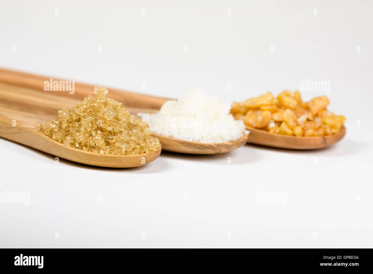 Sucre Demerara, le sucre granulé et un redimensionnement sur des cuillères en bois. Banque D'Images