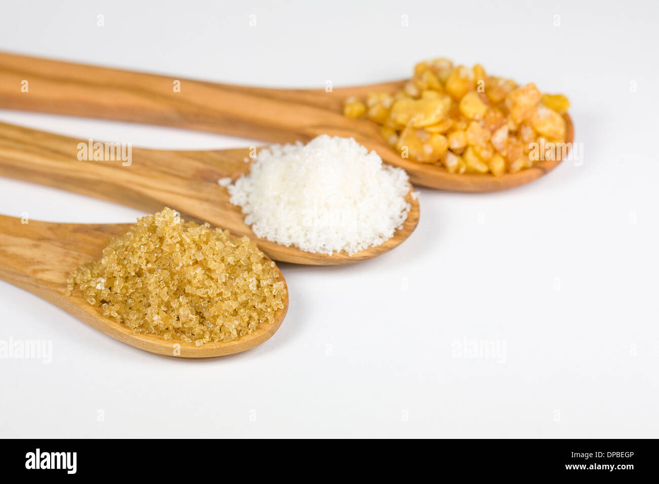 Sucre Demerara, le sucre granulé et un redimensionnement sur des cuillères en bois. Banque D'Images