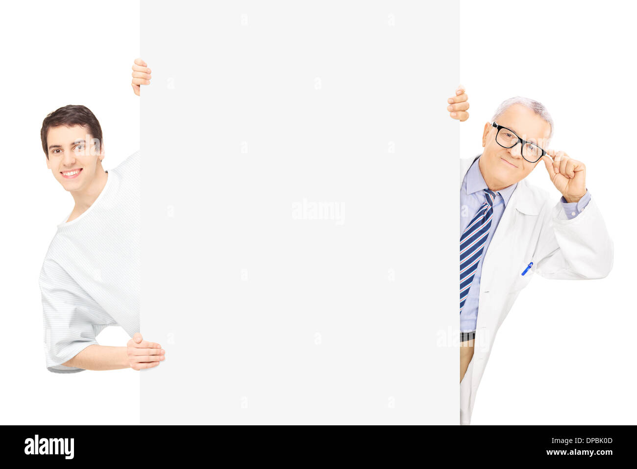 Young male patient et médecin d'âge moyen debout derrière panneau vierge, isolé sur fond blanc Banque D'Images