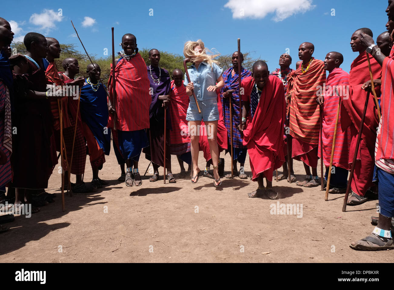 Une jeune danse touristique avec les guerriers Masaï dans la zone de conservation de Ngorongoro Crater Highlands de Tanzanie en Afrique Banque D'Images