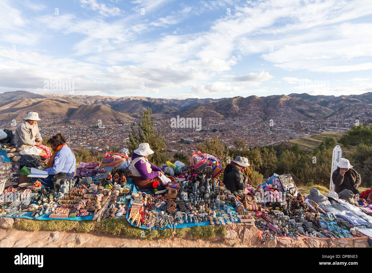 Les femmes vendant de l'artisanat sur une colline, la ville de Cusco (Pérou) en arrière-plan Banque D'Images