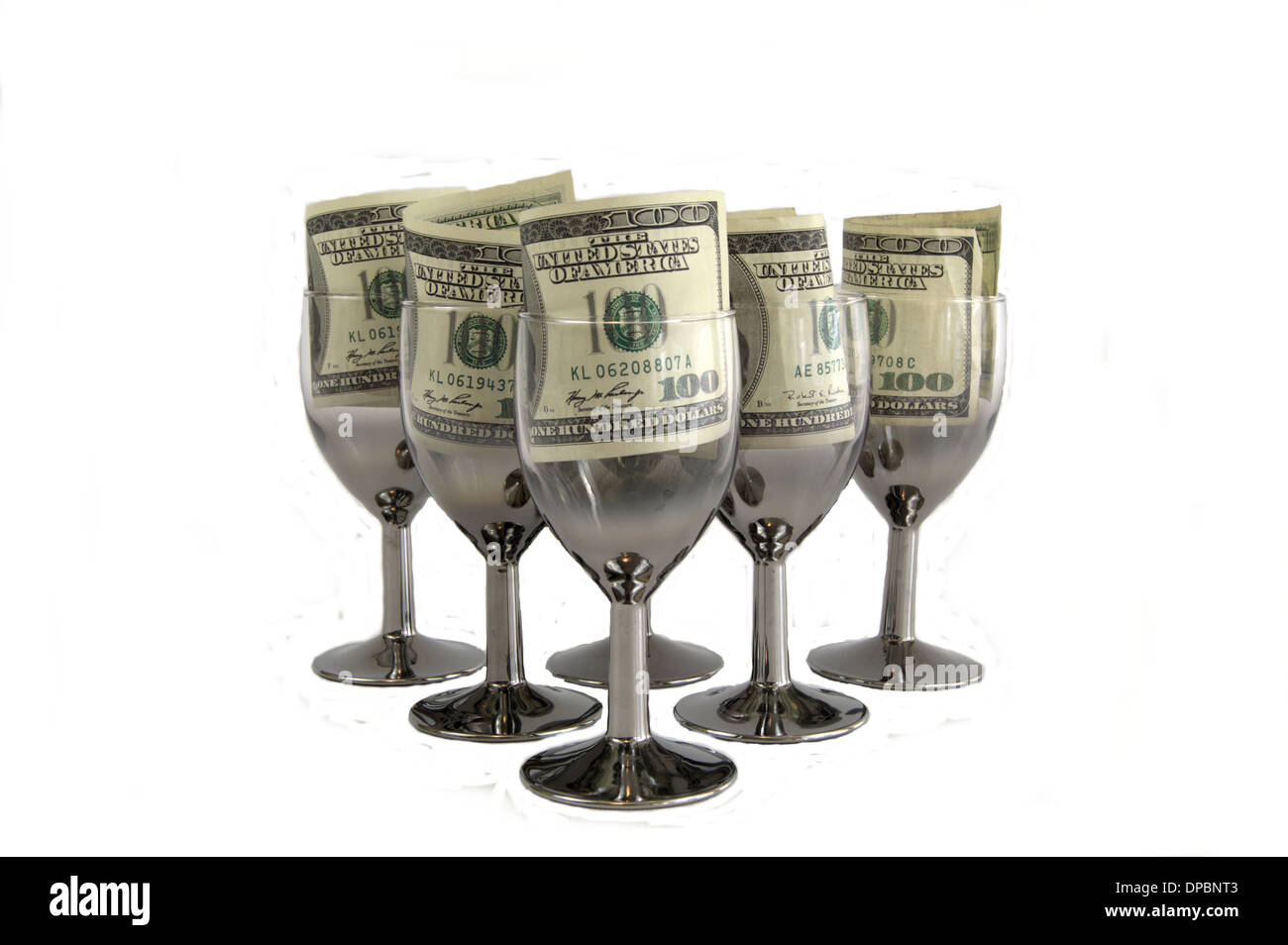 Une centaine de dollars dans des verres à vin. Banque D'Images