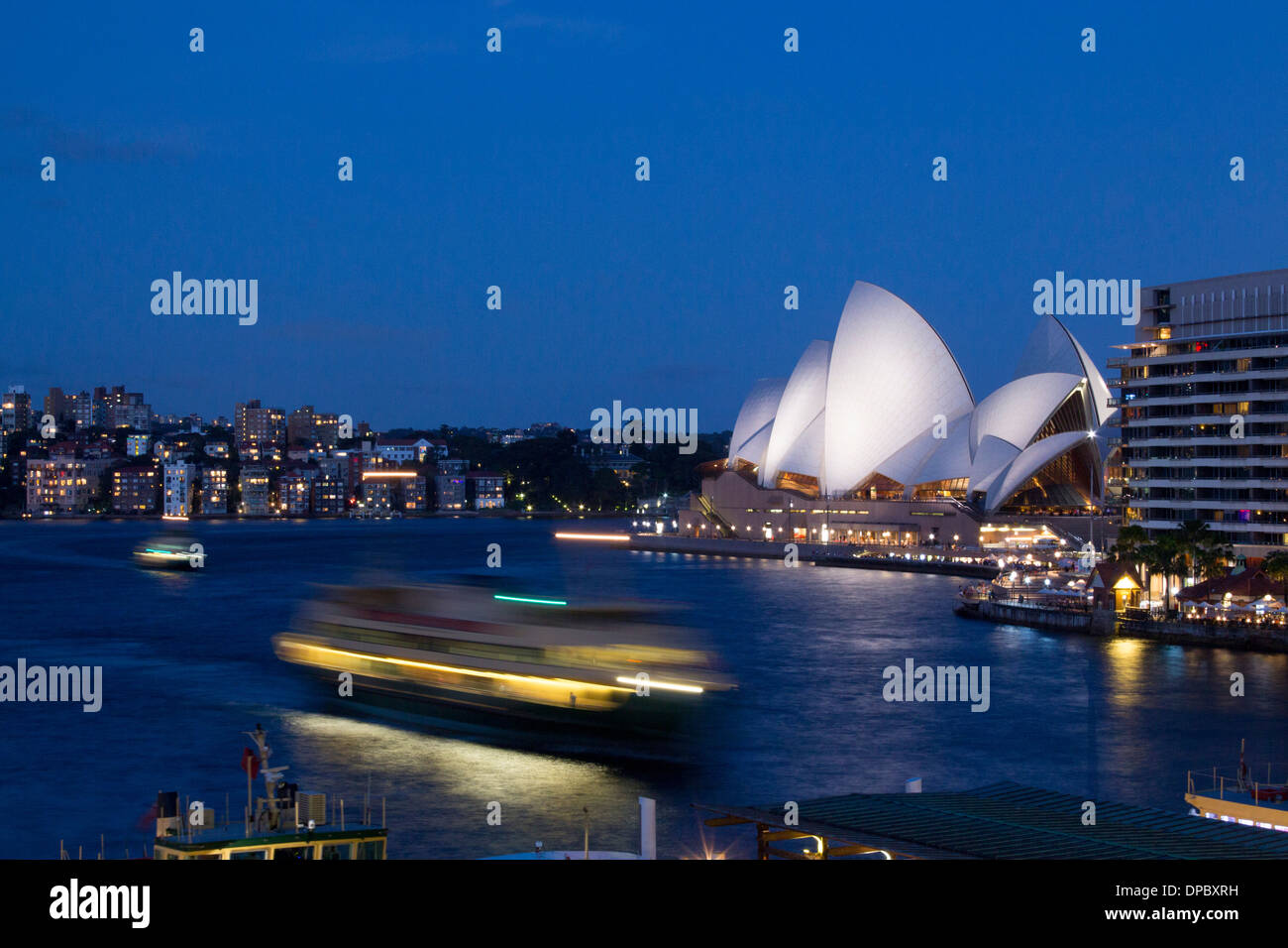Circular Quay au crépuscule la nuit tombée avec l'arrivée des ferries et l'Opéra en arrière-plan Sydney NSW Australie Nouvelle Galles du Sud Banque D'Images