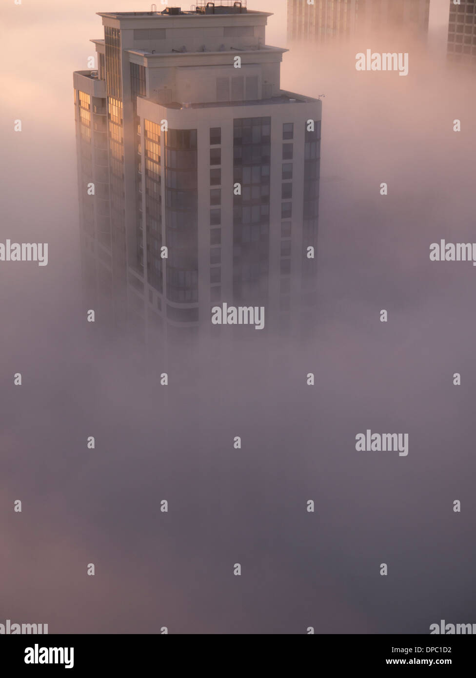 Brouillard tôt le matin par le lac Michigan. Blocs d'habitation s'élèvent au-dessus des nuages bas. Pris d'un océan sur Lakeshore East Banque D'Images