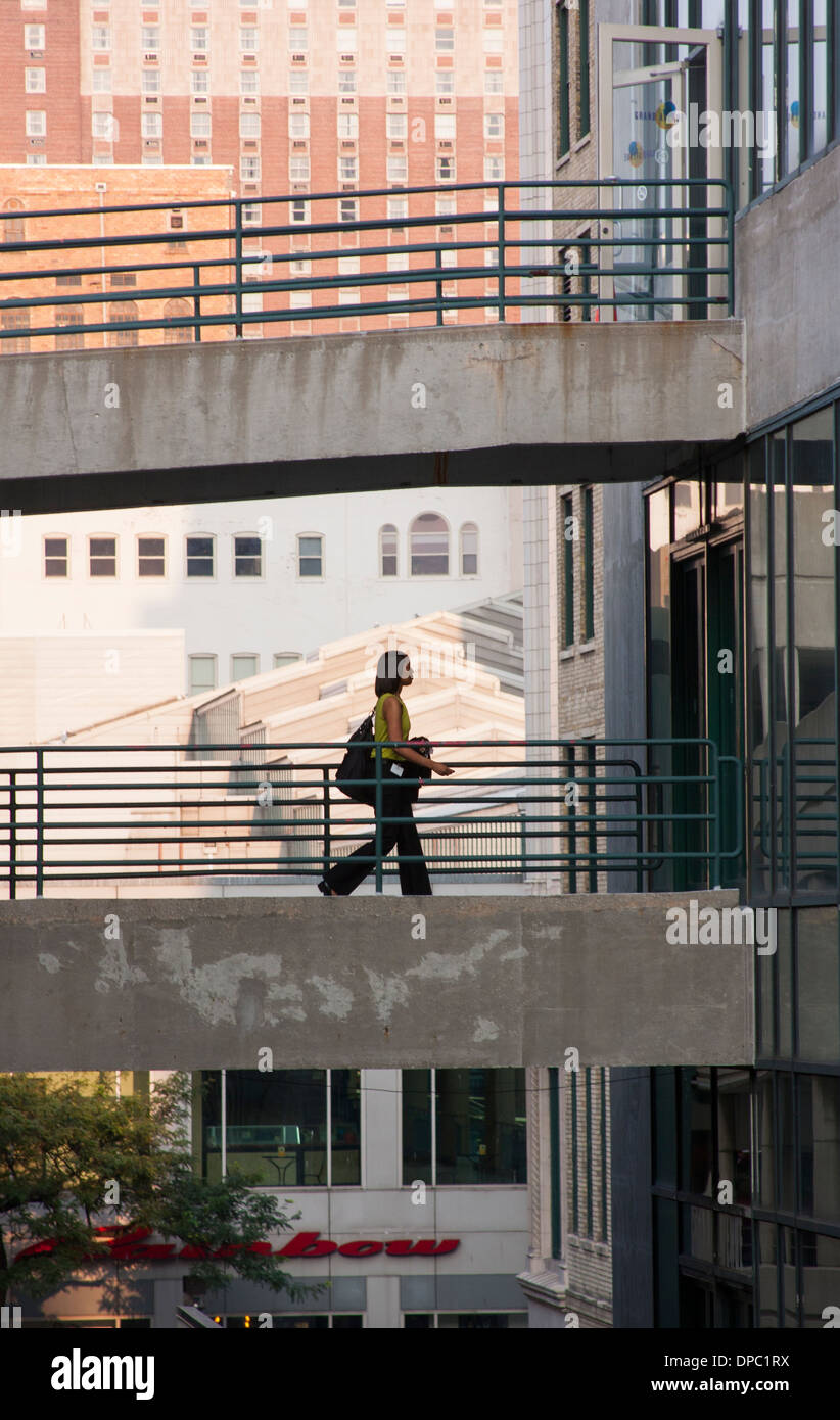 Une femme d'affaires à pied par une passerelle à partir d'une structure de stationnement dans un immeuble d'affaires Grand Avenue Mall Milwaukee WI Banque D'Images