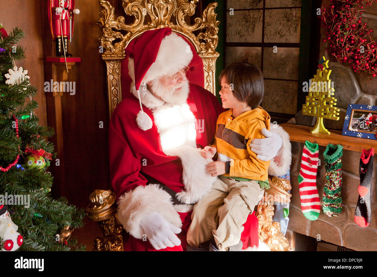 Enfant assis sur les genoux du Père Noël Banque D'Images