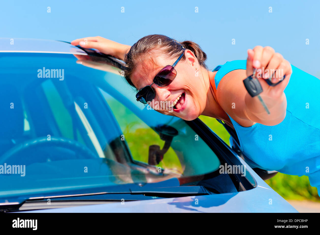 Happy woman montrant une voiture neuve de touches Banque D'Images