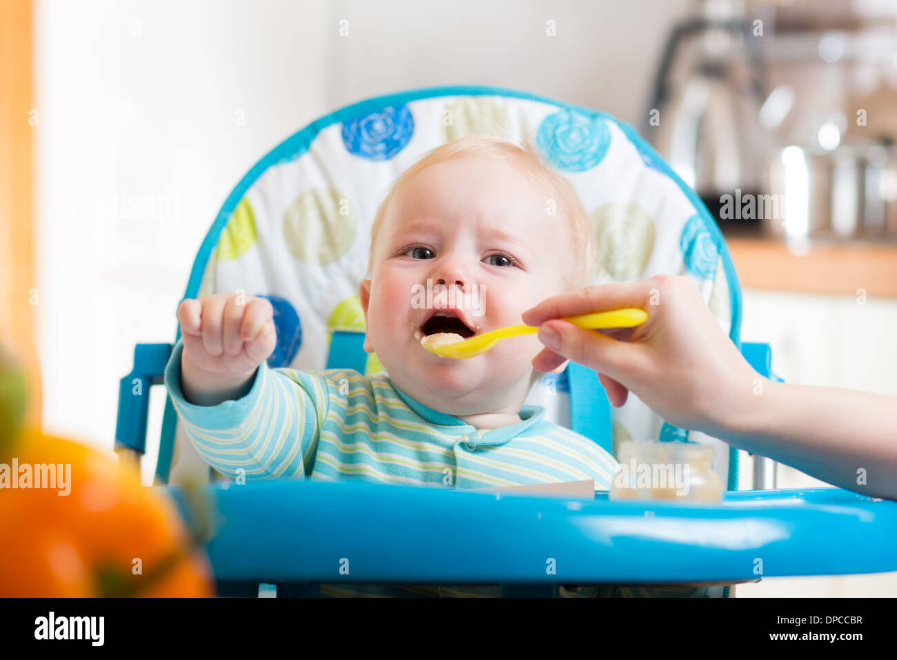 L'alimentation de la mère bébé capricieux avec une cuillère Banque D'Images