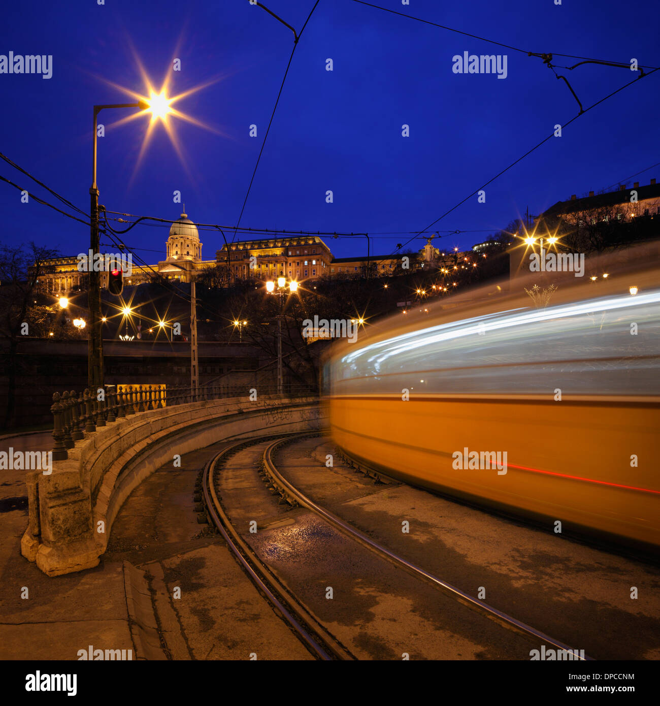 Des sentiers de lumière à partir d'un train qui passe à Budapest avec le Château de Buda en arrière-plan Banque D'Images