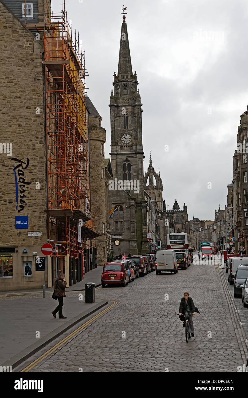 Cycliste solitaire sur rue principale pavée avec Édimbourg le Tron Kirk à gauche Banque D'Images