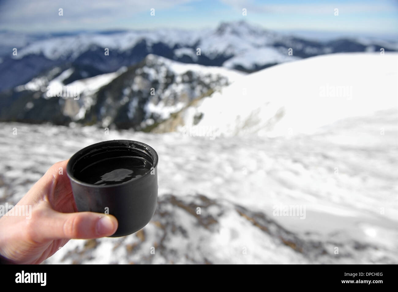 Main tenant une tasse de thé chaud en montagne en hiver Banque D'Images