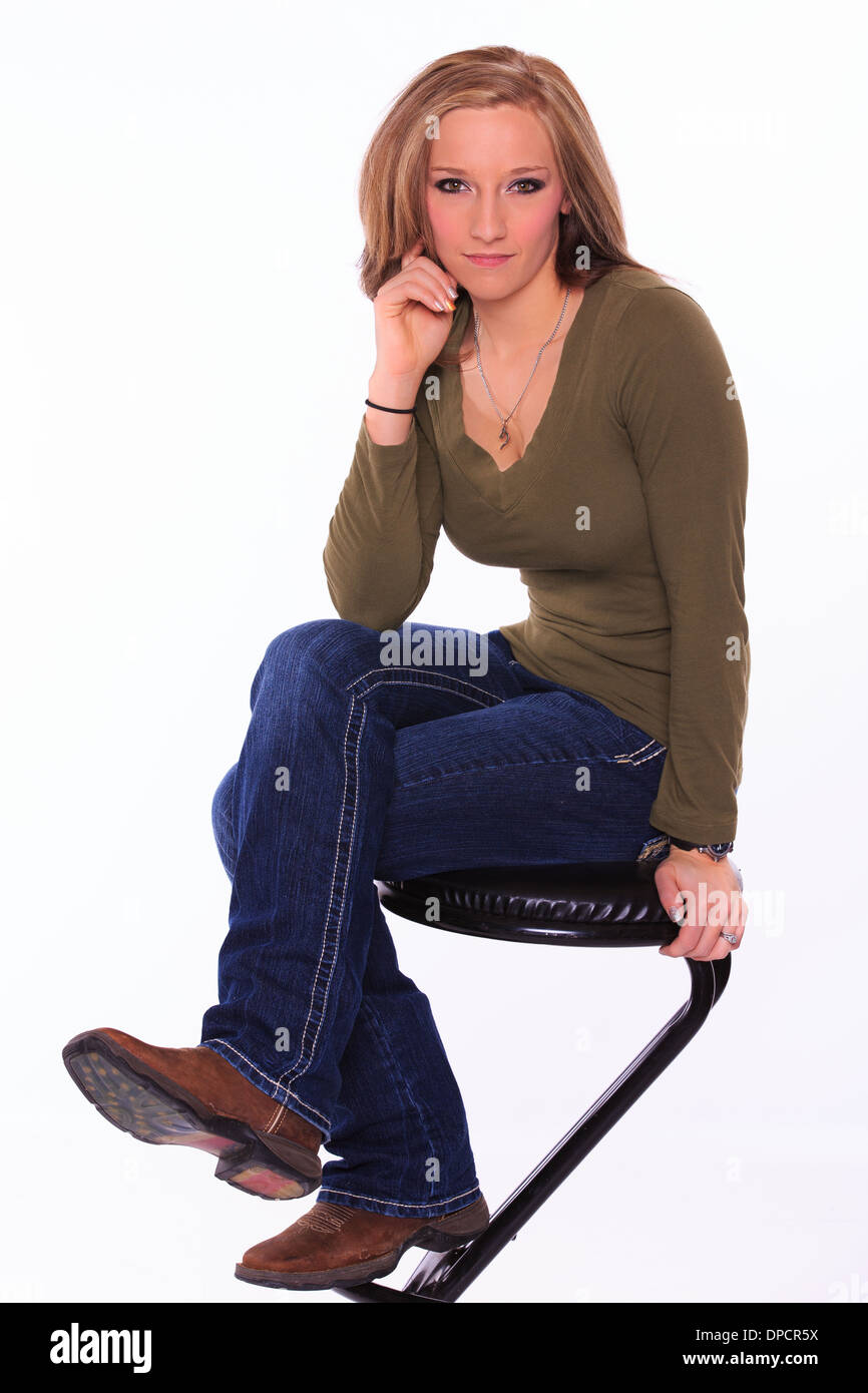 Portrait d'une jeune femme assise sur un tabouret Banque D'Images