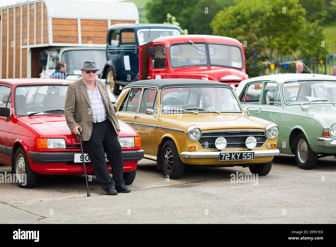 Un agriculteur s'appuie contre une Ford Fiesta à côté d'un Austin Morris et communauté rurale Humber Ford festival à la ferme en Irlande du Nord Banque D'Images