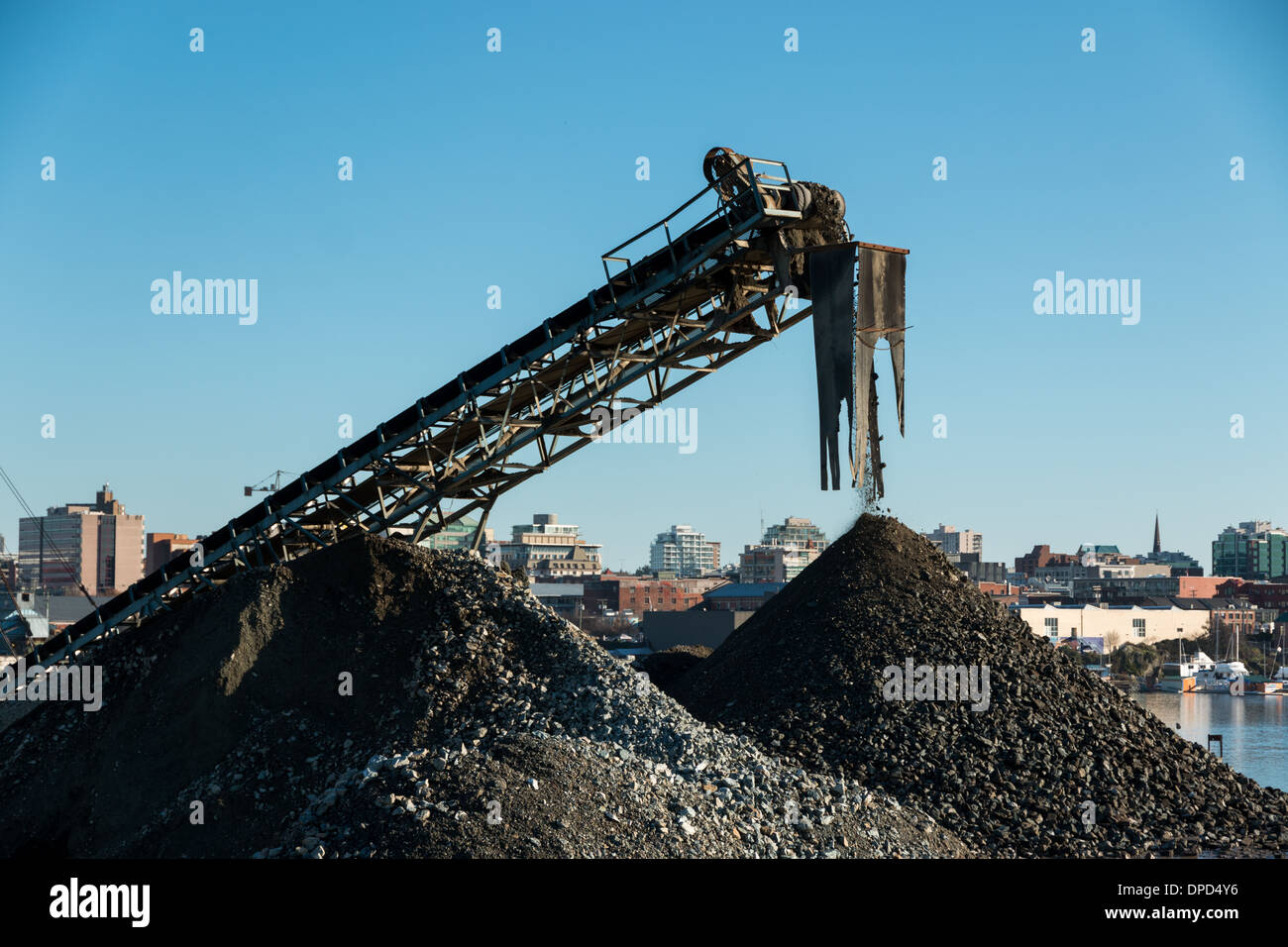 Un convoyeur dans une ville de l'usine de gravier gravier et rock piles pour une utilisation sur les chantiers. Banque D'Images