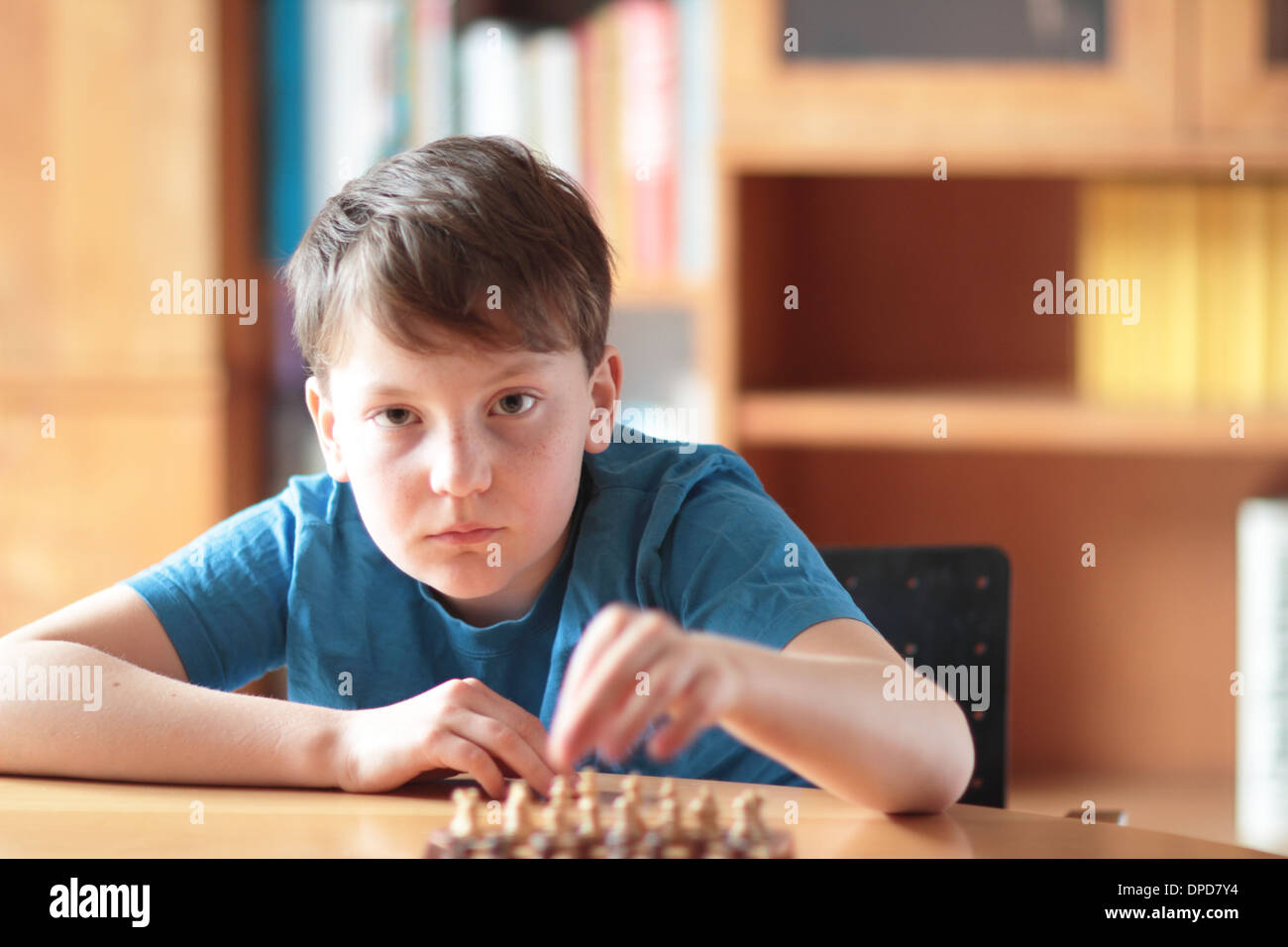 Jeune garçon jouant ches à la maison sur une table Banque D'Images