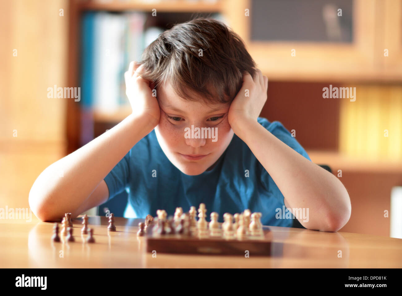 Jeune garçon jouant ches à la maison sur une table Banque D'Images