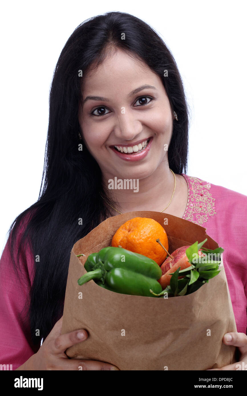 Happy young woman holding grocery bag avec plein de fruits et légumes Banque D'Images