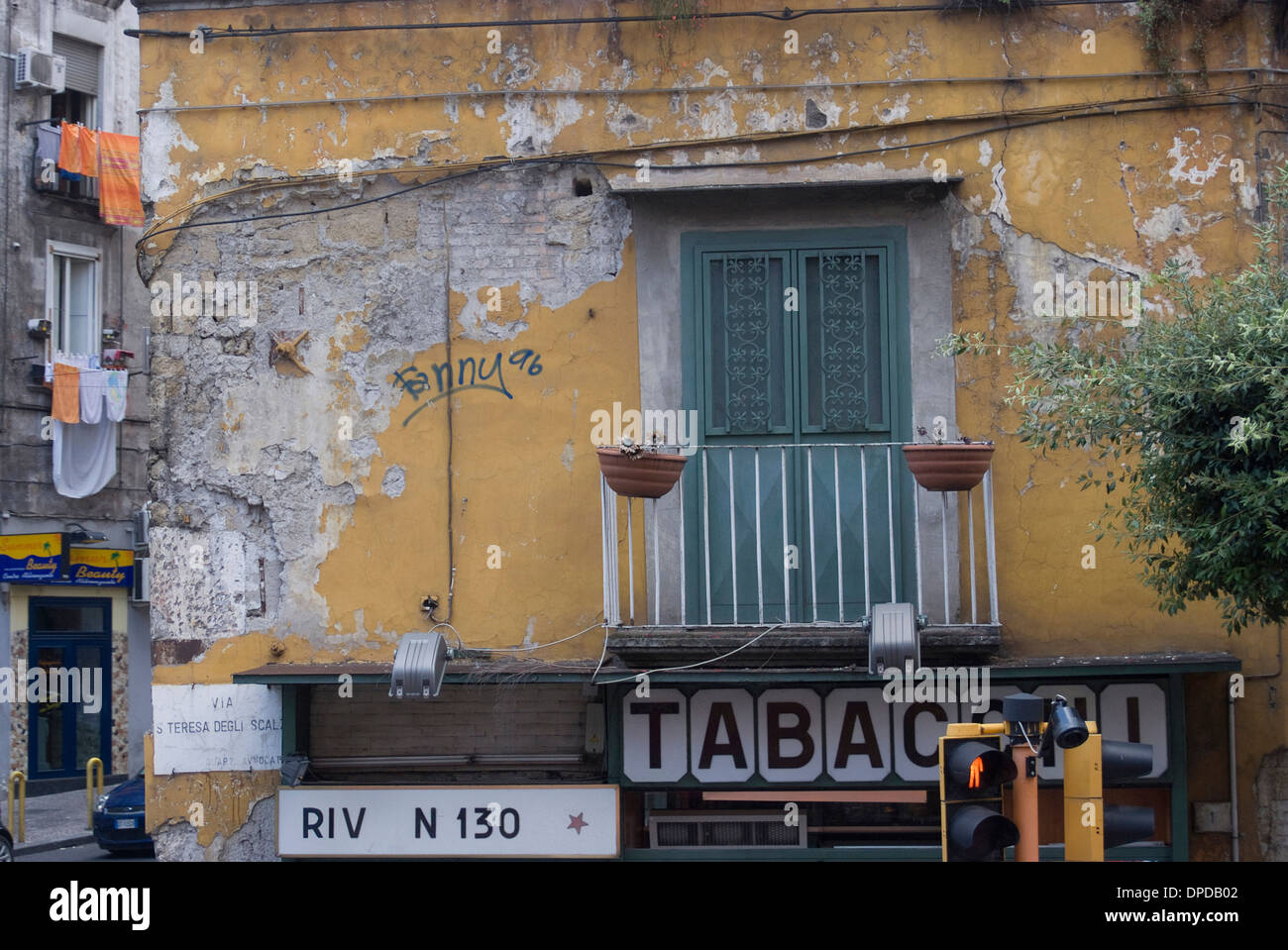 Soleil et météo-battues corner façade d'une résidence sur le dessus d'une boutique, Naples, Campanie, Italie Banque D'Images