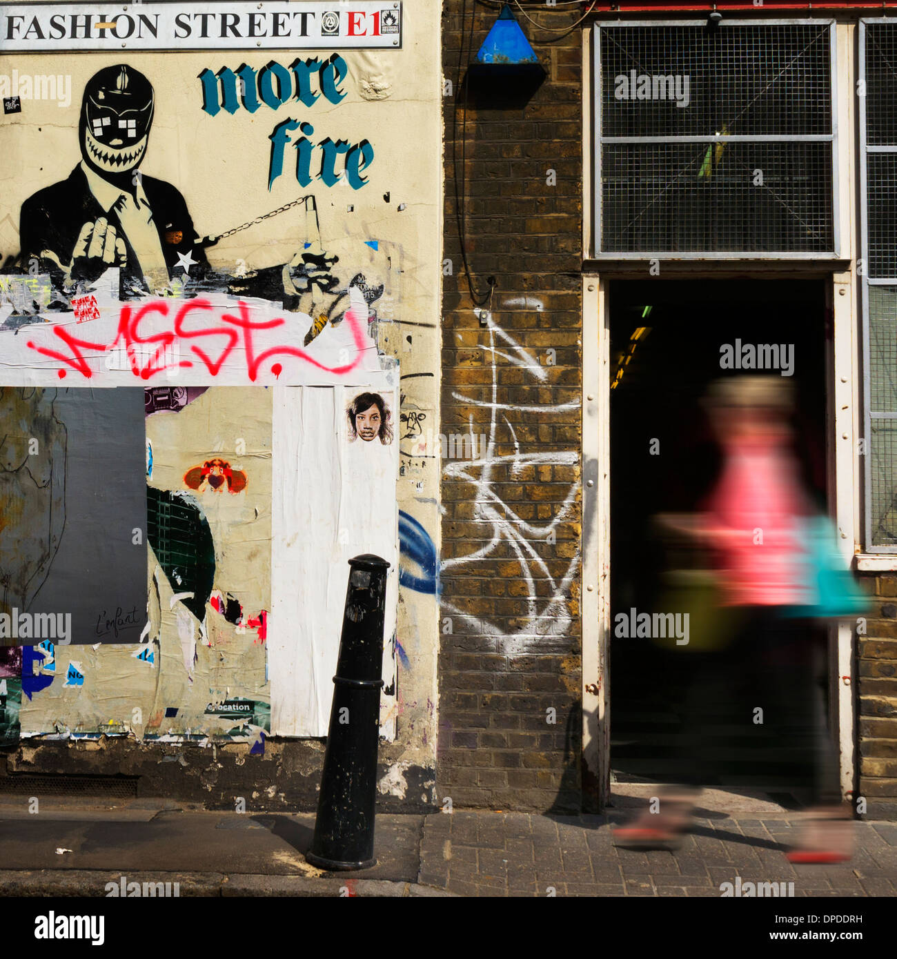 Jeune femme passant au graffiti Fashion Street Brick Lane, East London E1 UK Banque D'Images