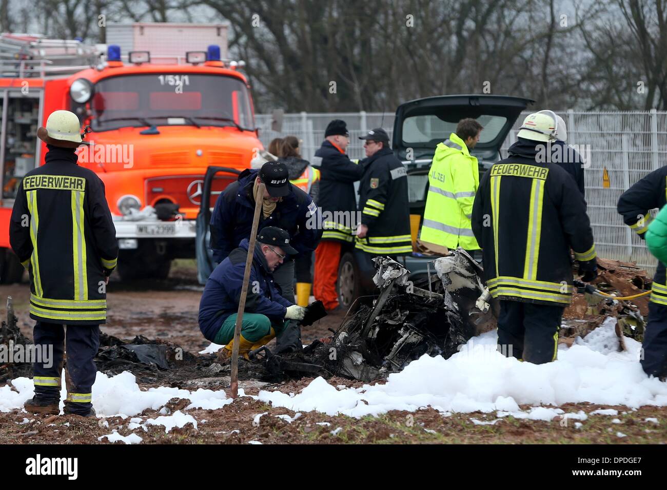 Rivenich, Allemagne. 13 Jan, 2014. Experts de l'Office fédéral allemand de l'Enquête sur les accidents d'aéronefs (BPA) examiner les pièces d'une épave d'avion sur le site où une entreprise moteur avion s'est écrasé près de Rivenich, Allemagne, 13 janvier 2014. L'avion doit atterrir à wa airstrip Foehren mais pris contact avec un pylône d'alimentation dans un brouillard épais. Les quatre passagers sont morts dans l'accident. Photo : THOMAS FREY/dpa/Alamy Live News Banque D'Images