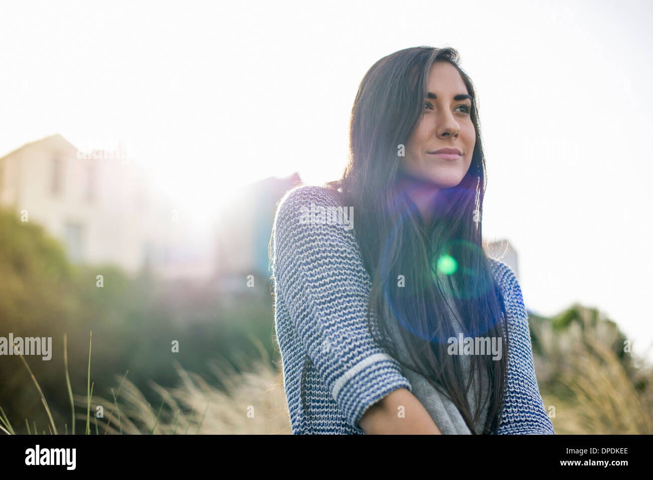 Jeune femme aux longs cheveux bruns à la lumière du soleil Banque D'Images