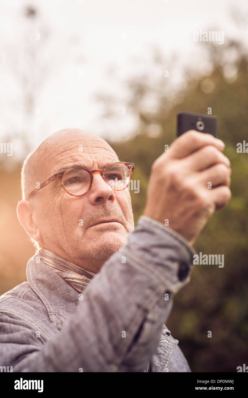 Senior man using cellular phone Banque D'Images