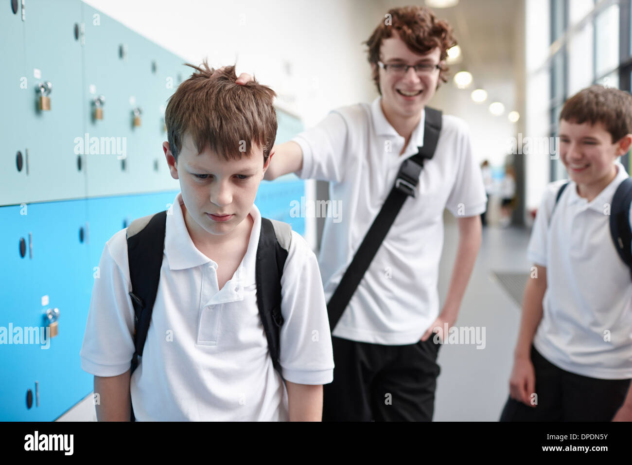 L'intimidation d'écolier dans couloir d'école Banque D'Images