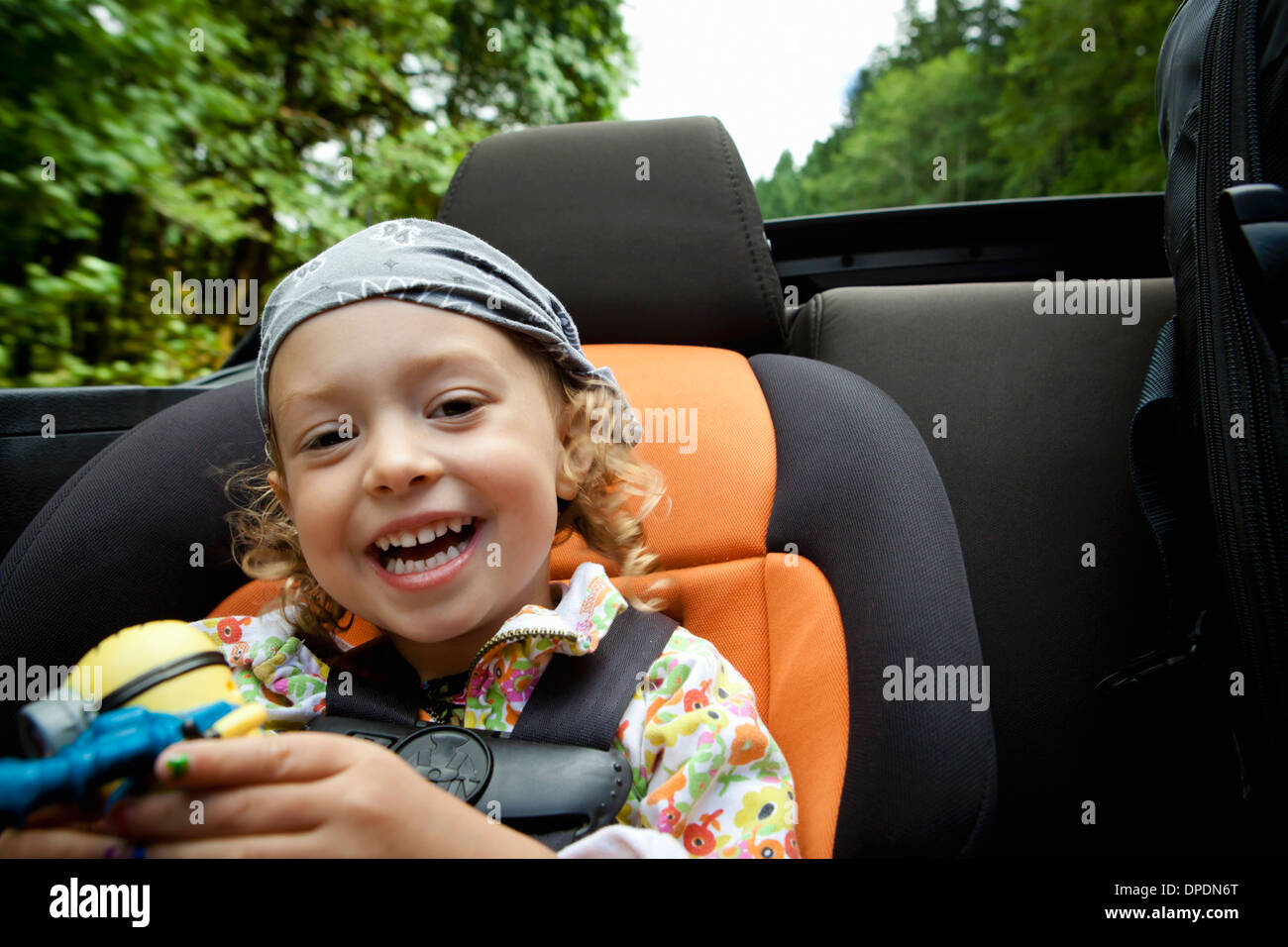 Portrait of female toddler in back seat of open soft top Banque D'Images