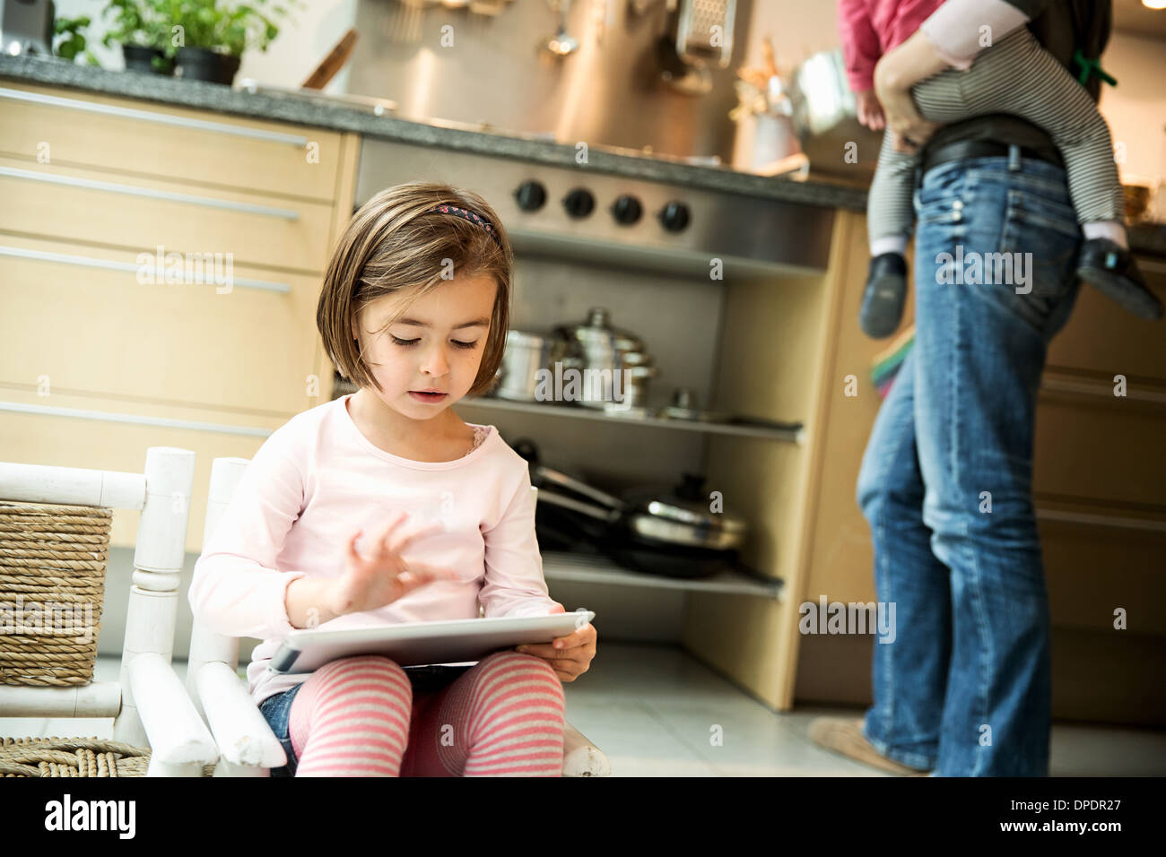 Girl using digital tablet in kitchen Banque D'Images Girl using digital tablet in kitchen Banque D'Images