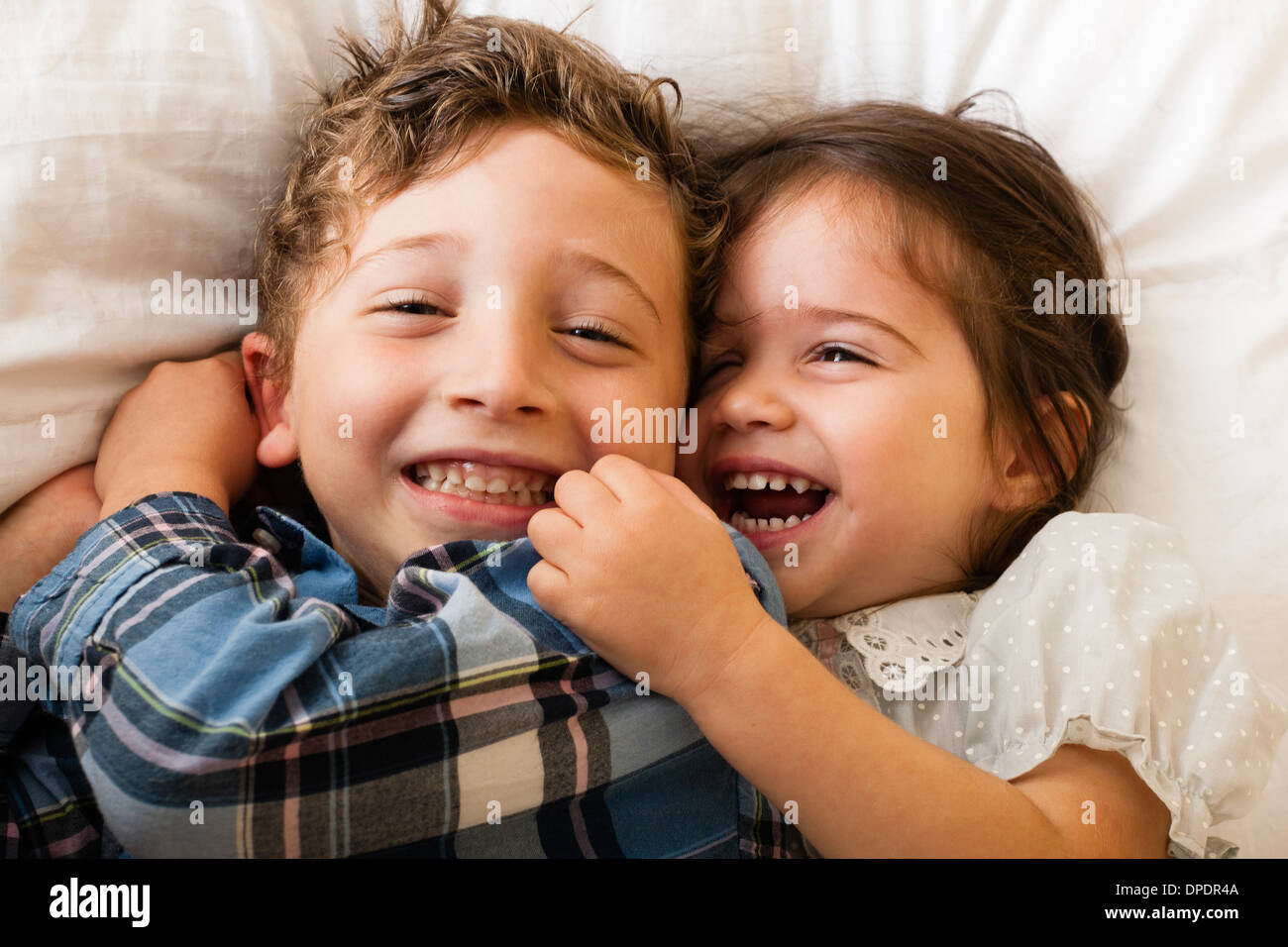 Children lying on bed Banque D'Images