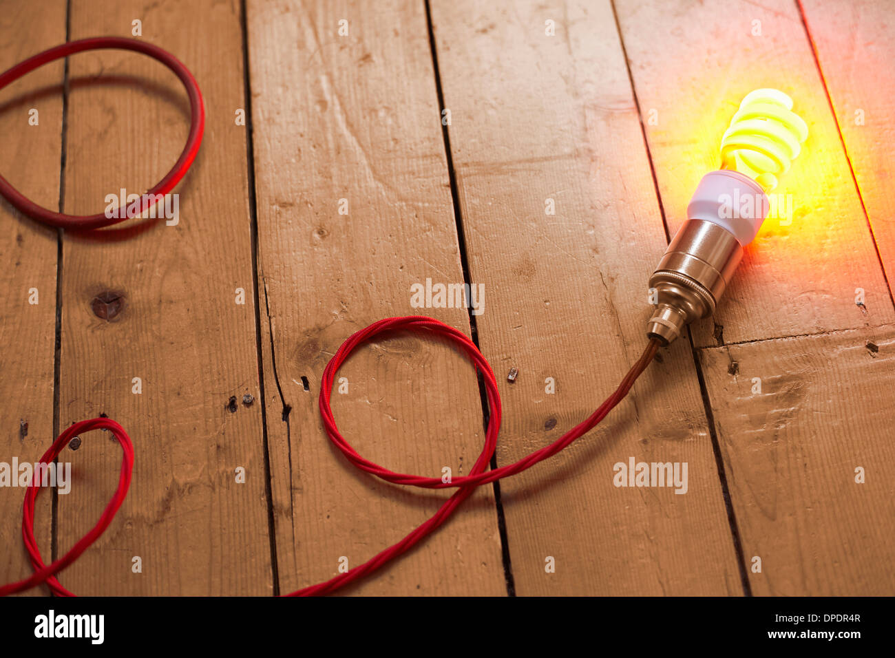 Still Life of energy saving lightbulb sur planchers en bois Banque D'Images