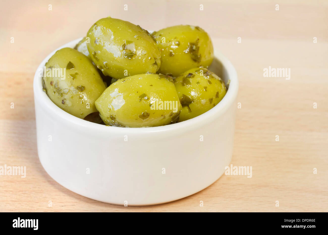 Bol d'olives vertes avec vinaigrette aux fines herbes Banque D'Images