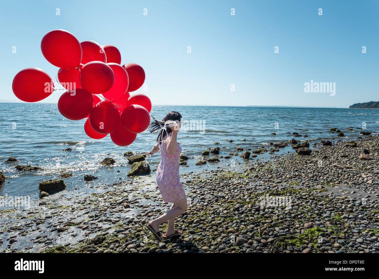 Young woman pulling bouquet de ballons Banque D'Images