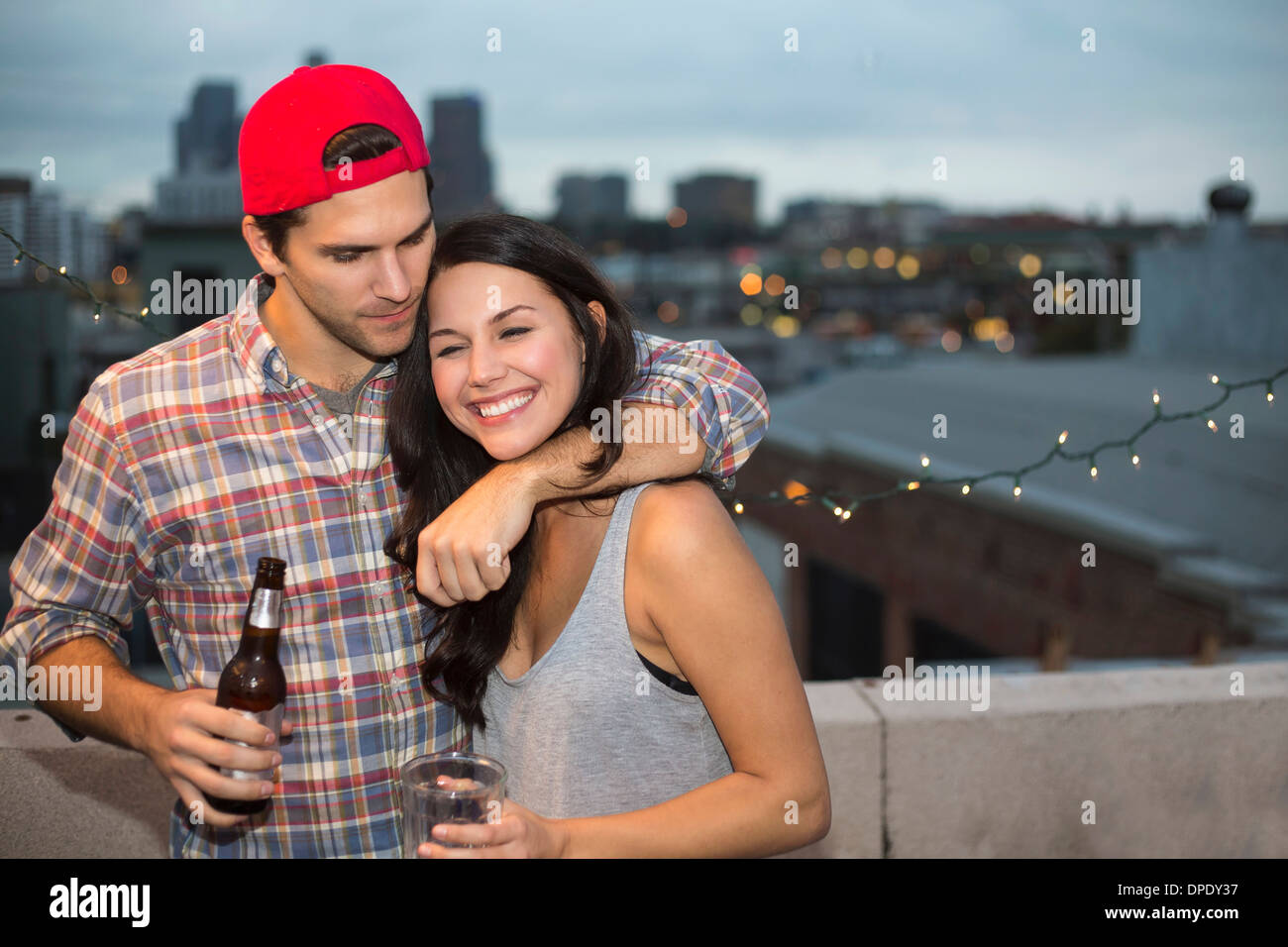 Young couple having fun at rooftop barbecue Banque D'Images