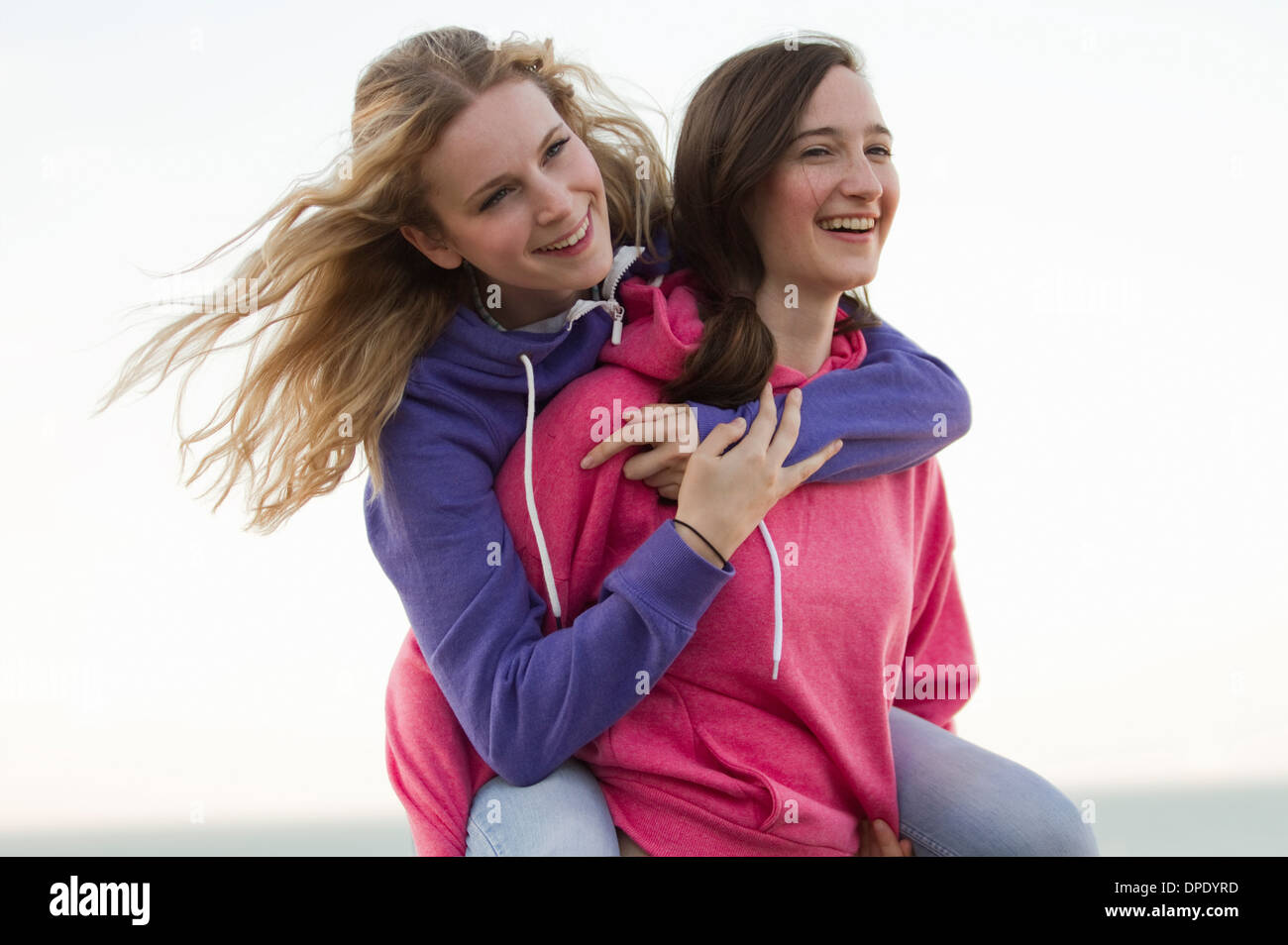 Deux jeunes femmes friends having fun on beach, Whitstable, Kent, UK Banque D'Images